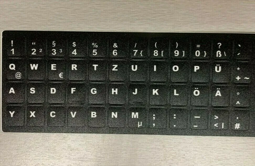 QWERTZ-Tastatur mit schwarzen Aufklebern und weißer Beschriftung für deutsche Sonderzeichen