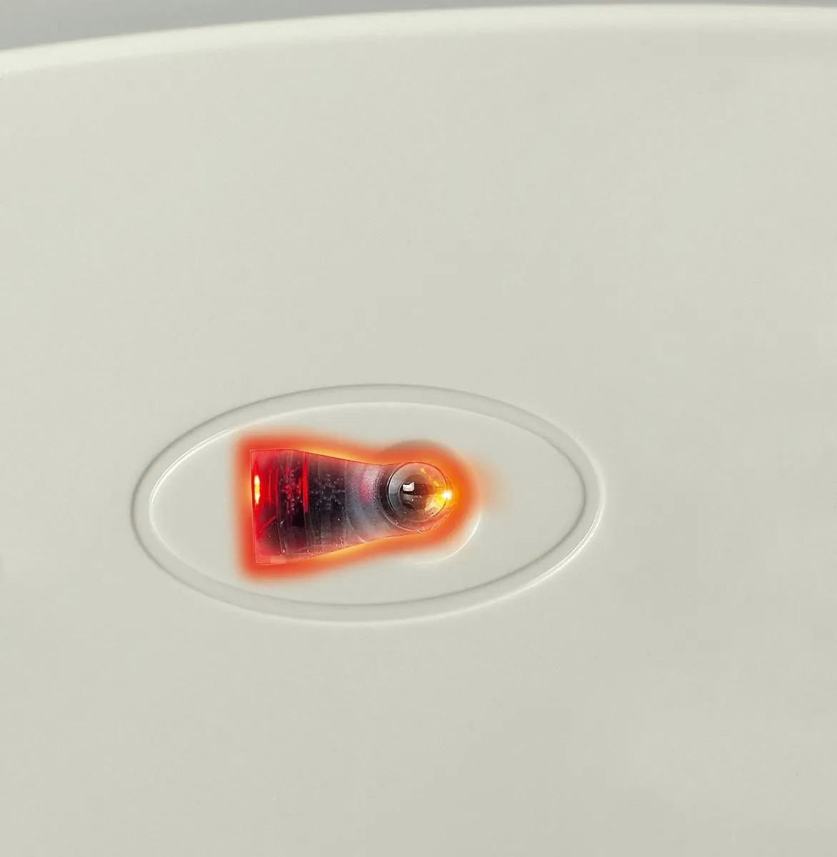 Nahaufnahme des optischen Sensors auf der Unterseite einer weißen Computermaus