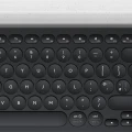 Oberansicht einer kabellosen Logitech Tastatur mit runden Tasten und weißer Gerätehalterung